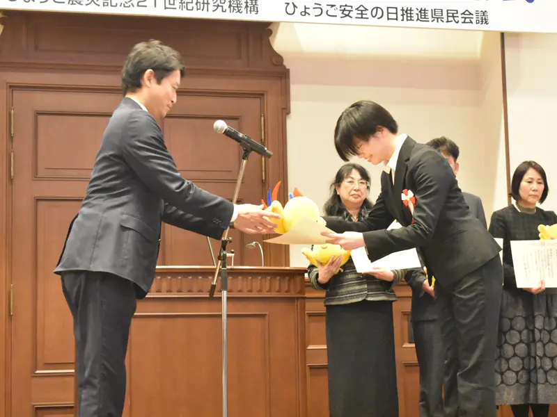 斎藤知事より、はばたんのぬいぐるみを受け取る佐伯ゼミの中島さん